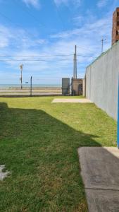 een grasveld naast een betonnen muur bij Duplex frente al mar in Mar del Plata