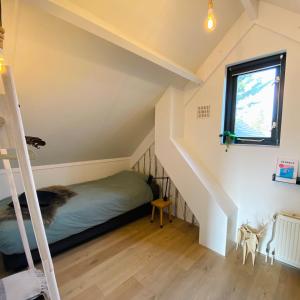 a bedroom with a bunk bed and a ladder at Huisje Hygge - luxe bungalow met grote tuin in Ewijk +43 photos