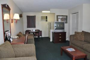 a living room with a couch and a tv at MERRIMAC INN & SUITES in Williamsburg