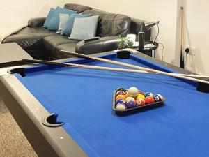 a living room with a pool table with two cue sticks at Team House -Walsall, M6 J7 - 11 beds, Nr B-Ham, Free Parking in Bescot