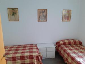 a room with two beds and two pictures on the wall at Pau-pi in Oliva