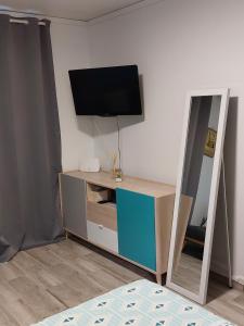 Cette chambre dispose d'une télévision et d'une commode avec un miroir. dans l'établissement Studio A14 près de la mer Village du Diamant, au Diamant