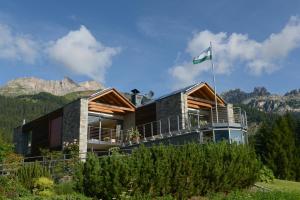 dom z flagą na górze w obiekcie Fior Tamion w mieście Vigo di Fassa