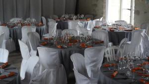 uma sala cheia de mesas com cadeiras brancas e copos em Le Château de mon Père em Villiers-aux-Corneilles