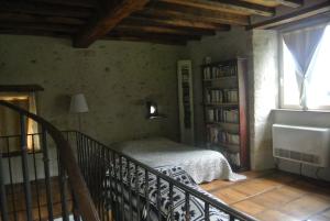 um quarto com uma cama e uma estante de livros em Le Château de mon Père em Villiers-aux-Corneilles