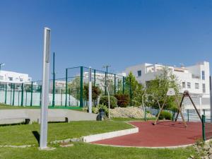 um parque com um baloiço e um parque infantil em Apartamento Puerta del Sol em Conil de la Frontera