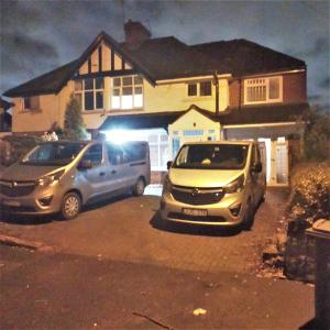 two cars parked in front of a house at night at Team House -Walsall, M6 J7 - 11 beds, Nr B-Ham, Free Parking in Bescot