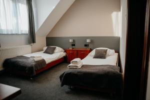 a bedroom with two beds and a window at Hotel Resident in Nowa Sarzyna