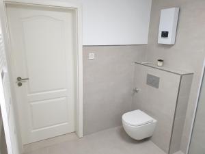 een badkamer met een toilet en een witte deur bij Schöne Wohnung über Wissen in Wissen