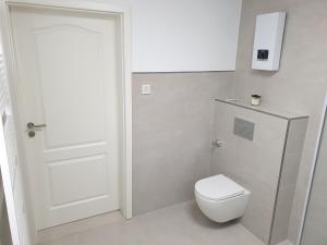 a bathroom with a toilet and a white door at Schöne Wohnung über Wissen in Wissen
