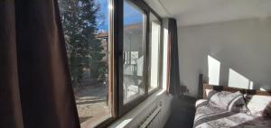 a window in a room with a bed and a view at Guest House Ela in Dolna Banya