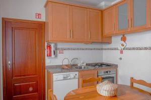 a kitchen with wooden cabinets and a table and a sink at Granny's house view in Funchal