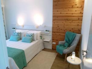 a bedroom with a bed and a chair at Alo Baía São Lourenço in Santa Bárbara