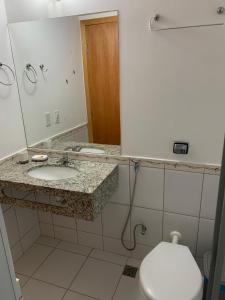 a bathroom with a sink and a toilet and a mirror at Aguas da Serra 322 A in Rio Quente