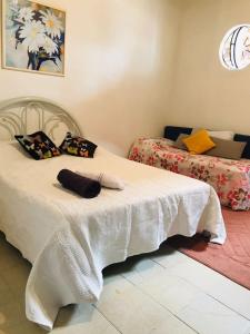 1 Schlafzimmer mit 2 Betten und weißer Bettwäsche in der Unterkunft Guest House Nosso Aconchego in Teresópolis