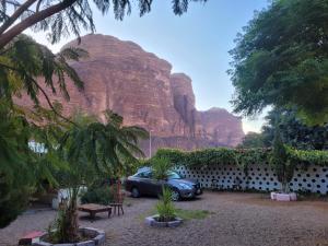a car parked in front of a mountain at WadiRum Village Lodge in Wadi Rum