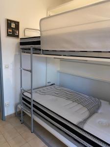 Cette chambre comprend une pile de lits superposés. dans l'établissement T2 Rez de jardin 300m Plage de Beaucours Sanary sur Mer, à Sanary-sur-Mer