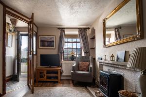 a living room with a tv and a chair and a mirror at Homely cottage with garden and mountain-view in Blaenau-Ffestiniog