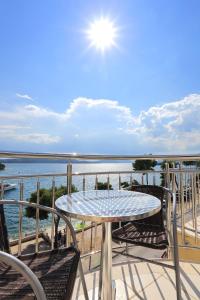 een tafel en stoelen op een balkon met uitzicht op het water bij Apartments Dado Trogir in Trogir