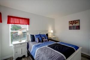 a bedroom with a bed with blue pillows and a window at SOLANA 7 Bed Rooms FAMILY VACATION VILLA-Private Pool and SPA in Davenport +58 photos