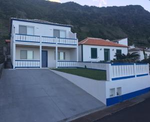 a white house with a driveway in front of a mountain at Alo Baía São Lourenço in Santa Bárbara