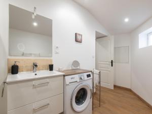 een keuken met een wasmachine en een wastafel bij Aventures modernes in Roanne