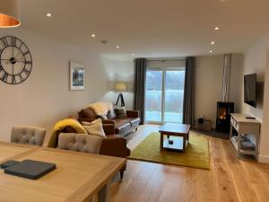 a living room with a couch and a table at The Heronry Hideaway with luxury hot tub in Ballachulish