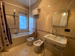 a bathroom with a sink and a toilet and a bath tub at Blue Door Hostel in Tirana