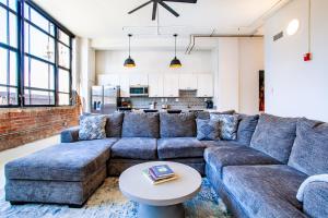 ノックスビルにあるSpacious Sterchi Loft Getaway- Downtown Getawayのリビングルーム(青いソファ、テーブル付)