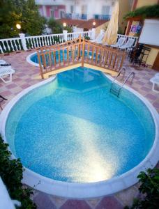 a large swimming pool with a wooden rail around it at Agali Hotel in Limenaria