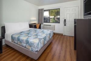 a bedroom with a large bed and a window at Motel 6-Santa Barbara, CA - State Street in Santa Barbara