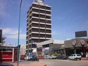 a tall building in front of a parking lot with cars at Comodo y amplio en el corazon de la Peninsula PDE Torre Amalfi in Punta del Este