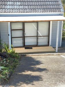 eine Veranda eines Hauses mit einer Tür in der Unterkunft Home and cottage for a family break away in Paihia