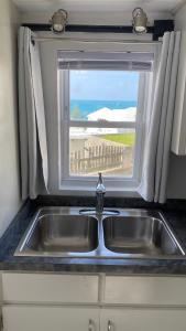 um lavatório numa cozinha com uma janela em Sunset Paradise Oceanview 1-Bedroom Holiday Home Walking Distance to Beaches & Railway Trail em Hamilton