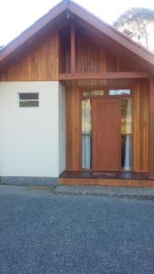 a small house with a brown and white door at Pousada Cabanas Flor de Mel in Urubici