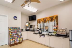 a kitchen with white cabinets and a counter at SureStay Hotel by Best Western Sarasota Lido Beach in Sarasota