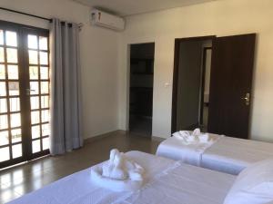 ein Schlafzimmer mit 2 Betten und Handtüchern darauf in der Unterkunft Casa Funchal Master in Lençóis