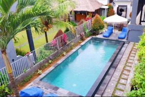 a swimming pool in a yard with a fence at Hello Canggu Homestay in Canggu