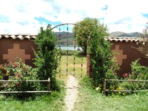 un jardín con una puerta y algunas flores en Ñustas de Piuray, en Urubamba