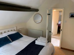 um quarto com uma cama com almofadas azuis e um espelho em Fern Cottage em Saltburn-by-the-Sea