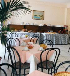 una sala da pranzo con tavolo, sedie, tavolo e sedie. di Hotel Scala Greca a Siracusa