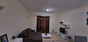 salon z kanapą i telewizorem w obiekcie Apartamento Teixeira w Espargos