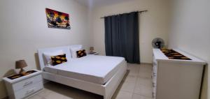 1 dormitorio con cama blanca y cortina negra en Apartamento Teixeira, en Espargos