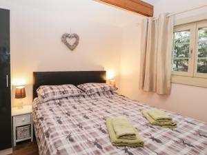 una camera da letto con un letto e due asciugamani di The Nook a Swindon