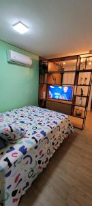 een slaapkamer met een bed en een flatscreen-tv bij Eco Resort - Praia dos Carneiros - ao lado da Igrejinha 227 in Tamandaré