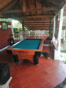 a pool table on a patio with a dog laying next to it at Finca Mirador la Giralda in Roldanillo