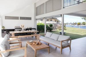 a living room with a couch and a table at Mysa Yamba - oceanstays in Yamba