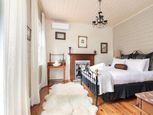 a bedroom with a bed and a fireplace at The Coach House in Mount Victoria