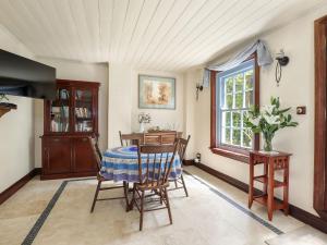 een eetkamer met een tafel en stoelen en een raam bij The Coach House in Mount Victoria