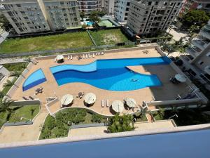 een uitzicht over een zwembad in een stad bij Lazer de resort a poucos passos da praia in Guarujá